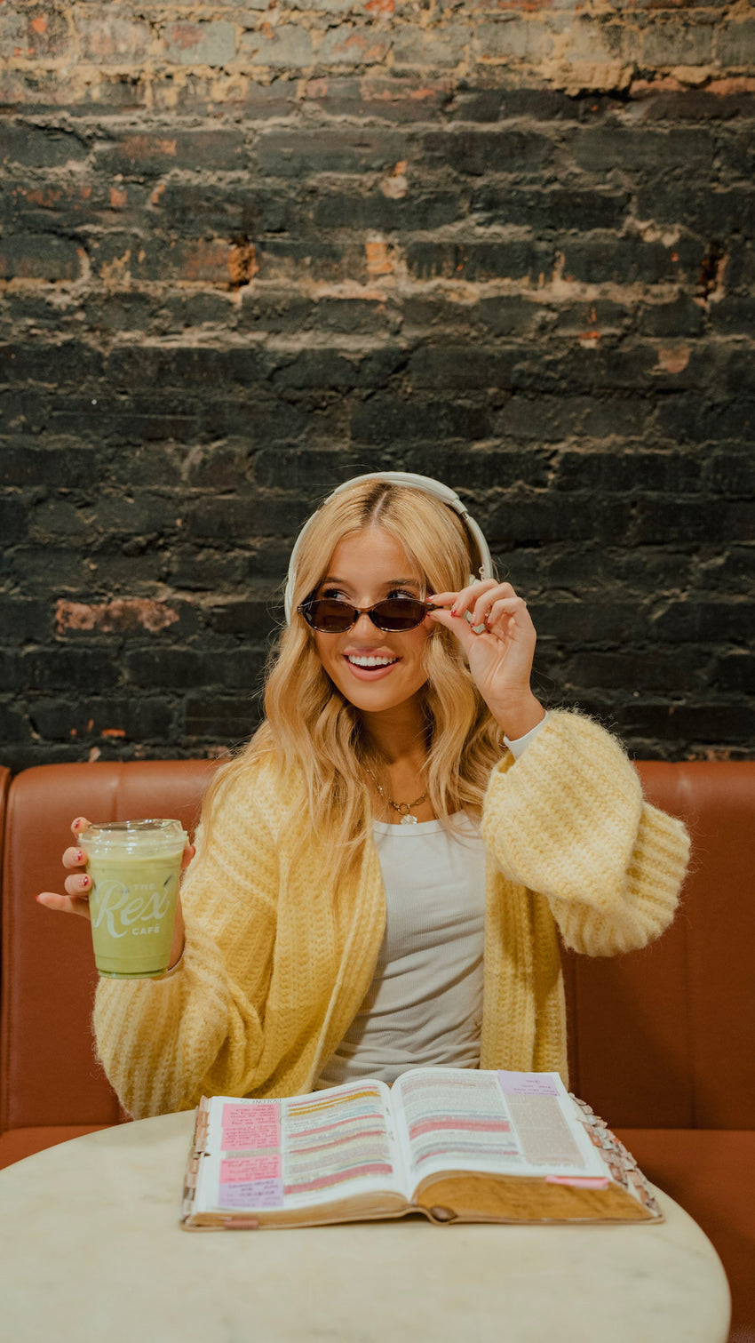 Amelia at a cafe with matcha and her open Bible